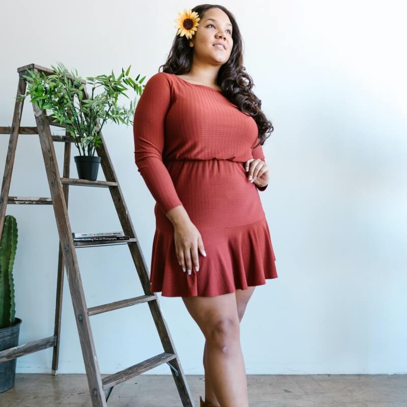 Petite and curvy woman in high wasted rust dress with rufled skirt